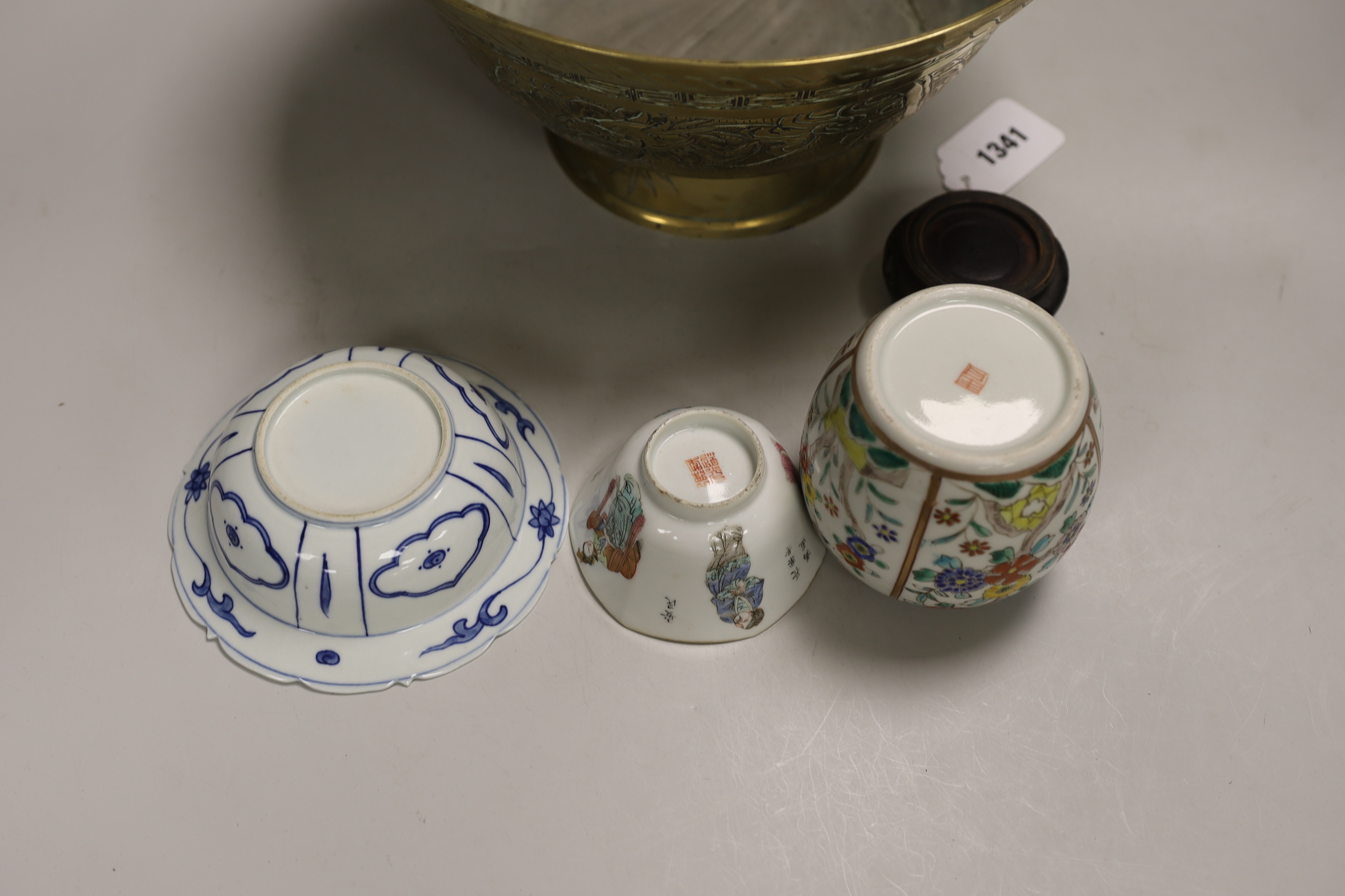 An early 20th century Chinese famille rose tea bowl and stand together with a brass ‘dragon’ bowl, a blue and white bowl and a jar